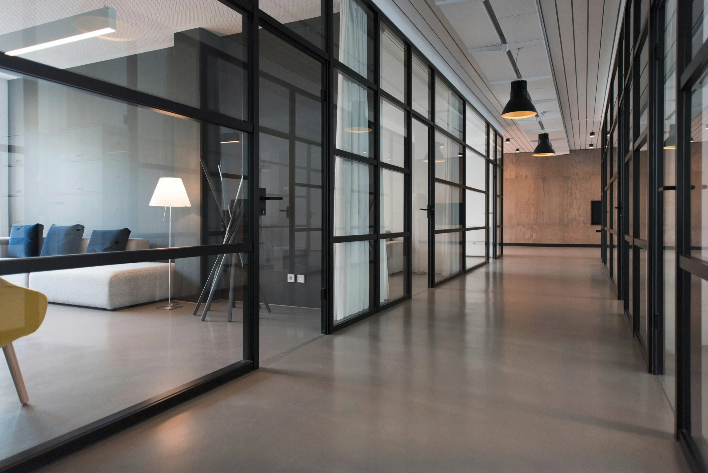 Modern office corridor with glass walls and polished floors